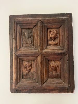 an image of a wooden panel with carved animals on it