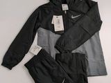 La veste et le pantalon Nike sont tous deux noirs et gris.