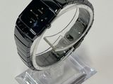 a black watch on a clear stand on a white surface