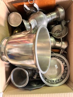 une boîte remplie de plats et de tasses en argent