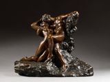 une statue en bronze représentant un homme et une femme assis sur un rocher