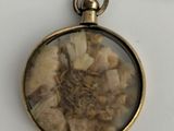 a picture of a necklace with a picture of a flower inside of it