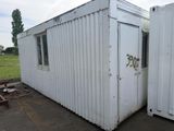 two white shipping containers sitting next to each other in a field