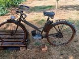 un vélo posé par terre dans l'herbe