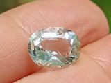 quelqu'un tient dans sa main un diamant vert et blanc