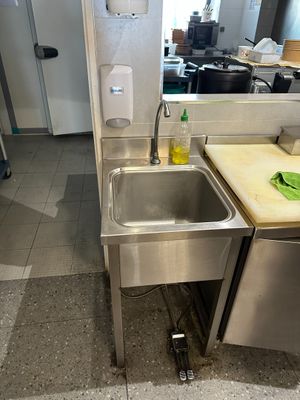 a stainless steel sink in the corner of a kitchen