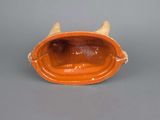 an orange ceramic bowl with horns on the side of it