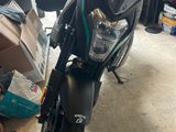 a motorcycle parked in a garage with boxes on the floor