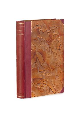 un vieux livre à la couverture rouge posé sur une surface blanche