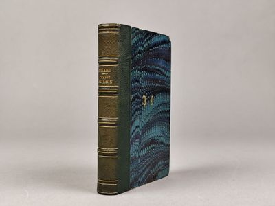 un vieux livre à la couverture bleue posé sur une surface blanche