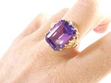 someone is holding a ring with an amethorate stone in it