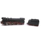 two toy trains sitting side by side on a white surface