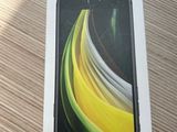 the box is open on a wooden table with a black phone in it