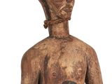 an old wooden statue of a man with a knife in his hand