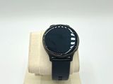 the watch is sitting on top of a stand on a white surface