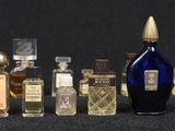 many different bottles of perfume sitting on a table