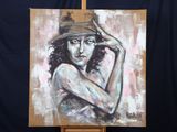un tableau représentant une femme coiffée d'un chapeau, posé sur un chevalet