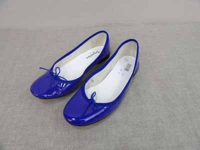 une paire de chaussures bleues posée sur un lit