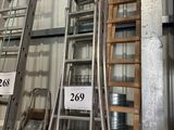 de nombreuses échelles empilées dans un entrepôt
