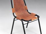 un fauteuil en cuir marron avec des pieds noirs et une structure noire