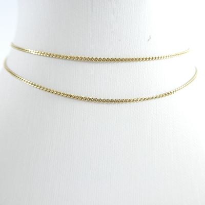 un gros plan sur un collier ras-du-cou en or porté par un mannequin