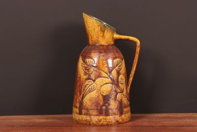 un pichet marron posé sur une table en bois