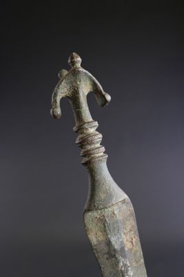 Poignard en bronze patiné. Pommeau découpé.