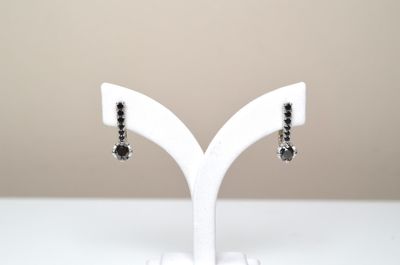 Une paire de boucles d'oreilles en argent 925 millièmes sert…