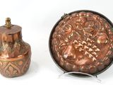 un petit vase en cuivre à côté d'un autre petit vase en cuivre