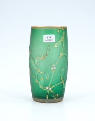 a green vase with gold designs on it on a white surface