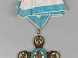 une médaille ornée d'une croix et entourée d'un ruban