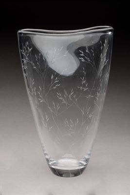 un vase en verre avec un oiseau sur une table