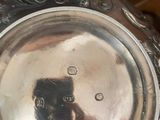 a person taking a picture of a silver plate on a table