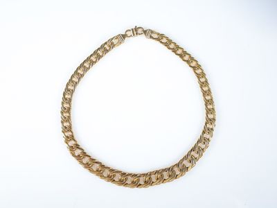 gros plan d'un collier en chaîne en or sur fond blanc