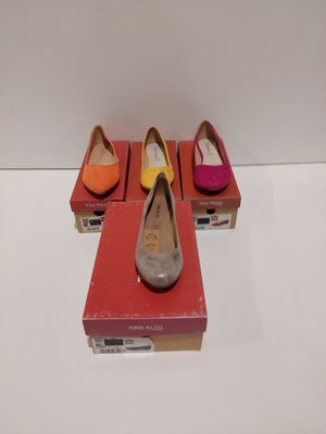 trois paires de chaussures sont posées sur une boîte rouge