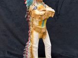 a figurine of a native american man holding a baseball bat