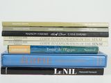 several books are stacked on top of each other on a white surface