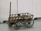 a small wooden wagon with a wooden seat on the floor