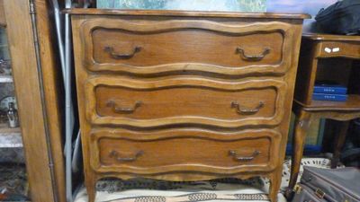 une commode en bois sur laquelle est posé un coussin rayé