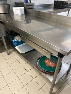 a stainless steel table in a kitchen with pots and pans on it