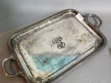 two silver trays sitting on a table next to each other