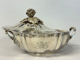 an antique silverplated bowl with a lid and handles on a white surface