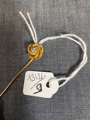 un gros plan d'une aiguille à laquelle est attachée une étiquette