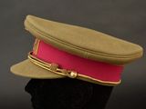 a military hat with a red band on top of a mannequin head