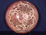 une assiette rouge et blanche ornée d'un motif représentant un oiseau