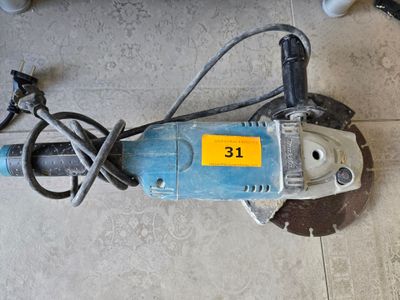 a small electric drill on the floor with a cord