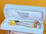 a small box with a pair of brooches in it