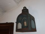 a green lantern hanging on the wall next to a mirror