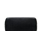 the small black leather bag is on a white surface