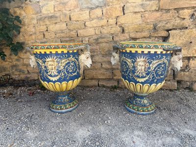 two large vases sitting next to each other on the ground